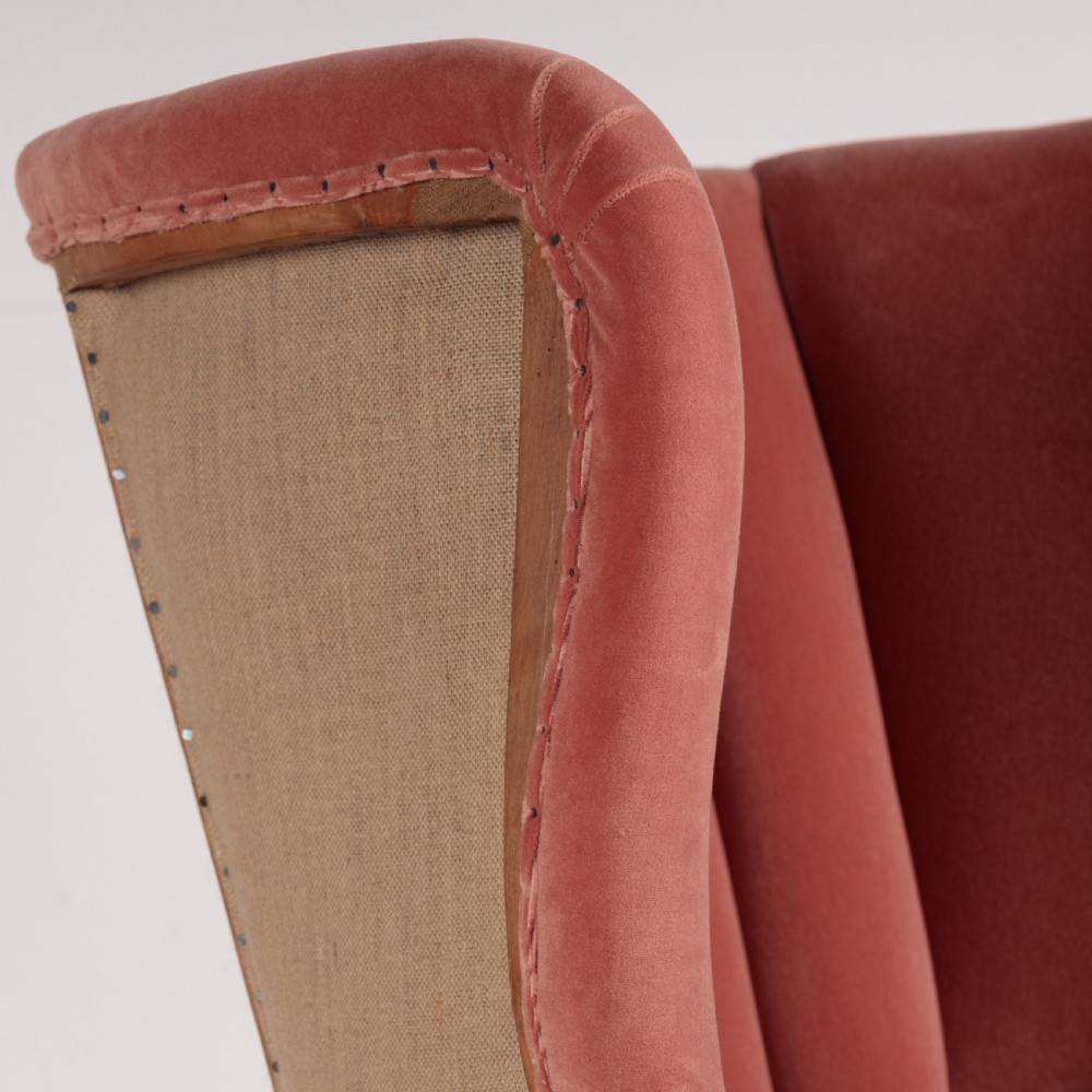 An 18th-century style barrel back armchair upholstered in dusty pink velvet with vertical channel quilting, standing on wooden legs with brass castors. View VIII