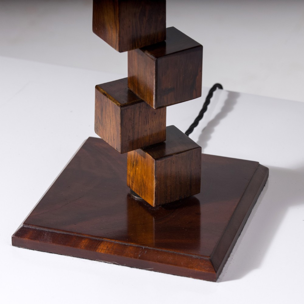 A mid-century modern wooden table lamp base constructed from offset stacked cubes terminating in a brass bulb fitting on a rectangular plinth. View V