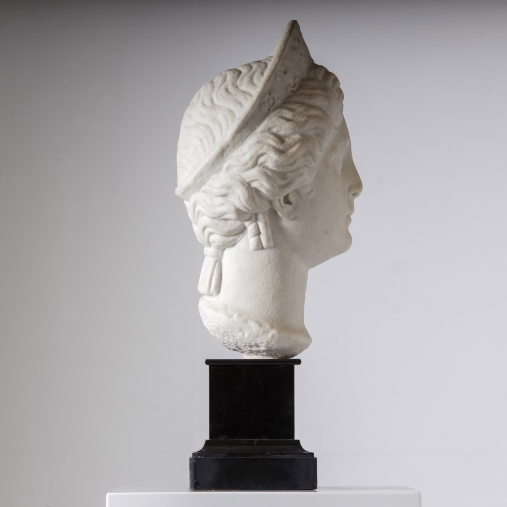 An off-white carved marble bust depicting the goddess Juno with wavy hair and a diadem, mounted on a square black marble plinth. View II