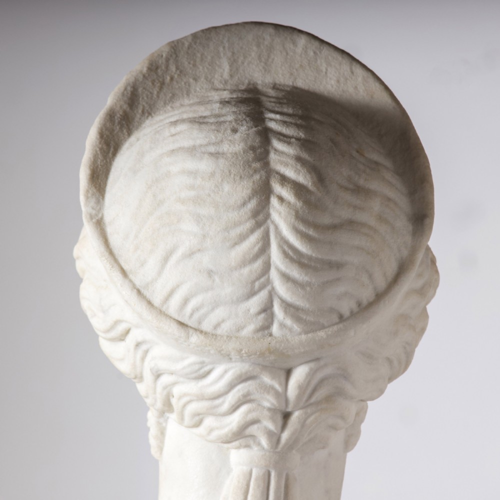 An off-white carved marble bust depicting the goddess Juno with wavy hair and a diadem, mounted on a square black marble plinth. View IX