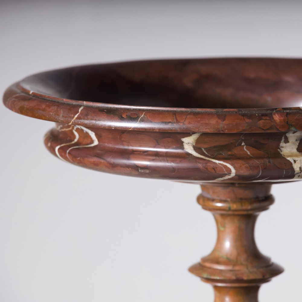 A carved reddish-brown marble tazza featuring a wide shallow dish, turned central stem, and circular moulded base. View VI