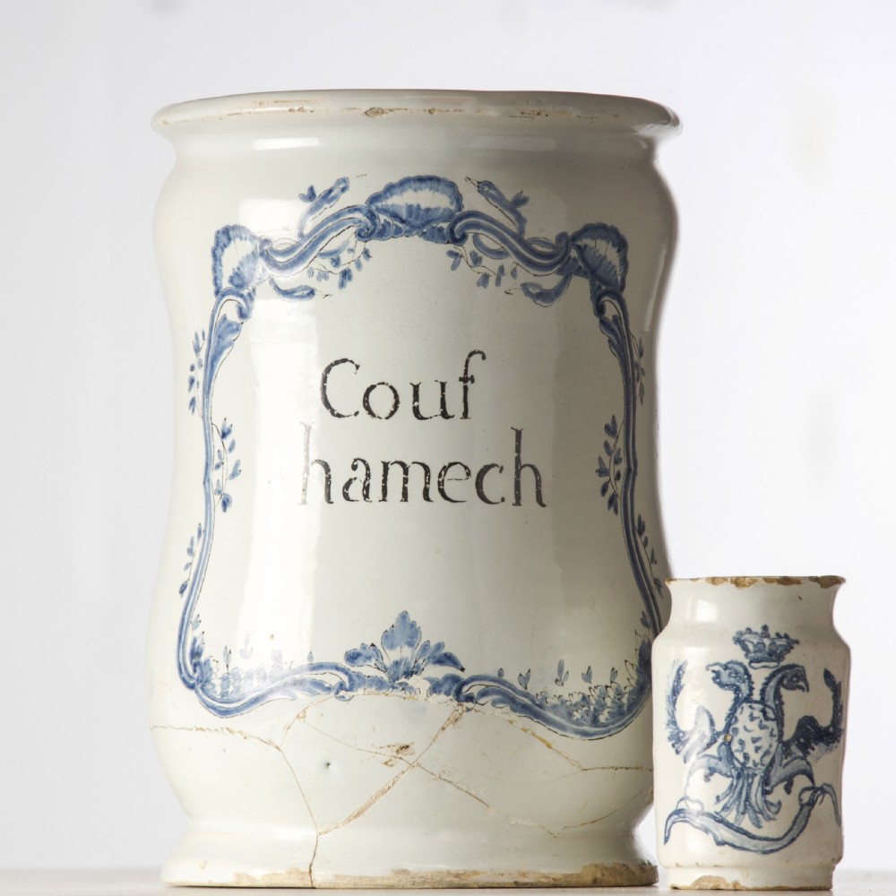 A cylindrical 19th-century tin-glazed ceramic pharmacy jar featuring a blue painted scrollwork cartouche with Latin text. View II