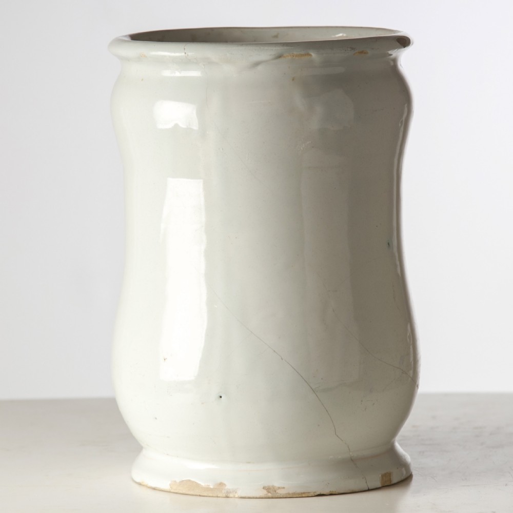 A cylindrical 19th-century tin-glazed ceramic pharmacy jar featuring a blue painted scrollwork cartouche with Latin text. View IV
