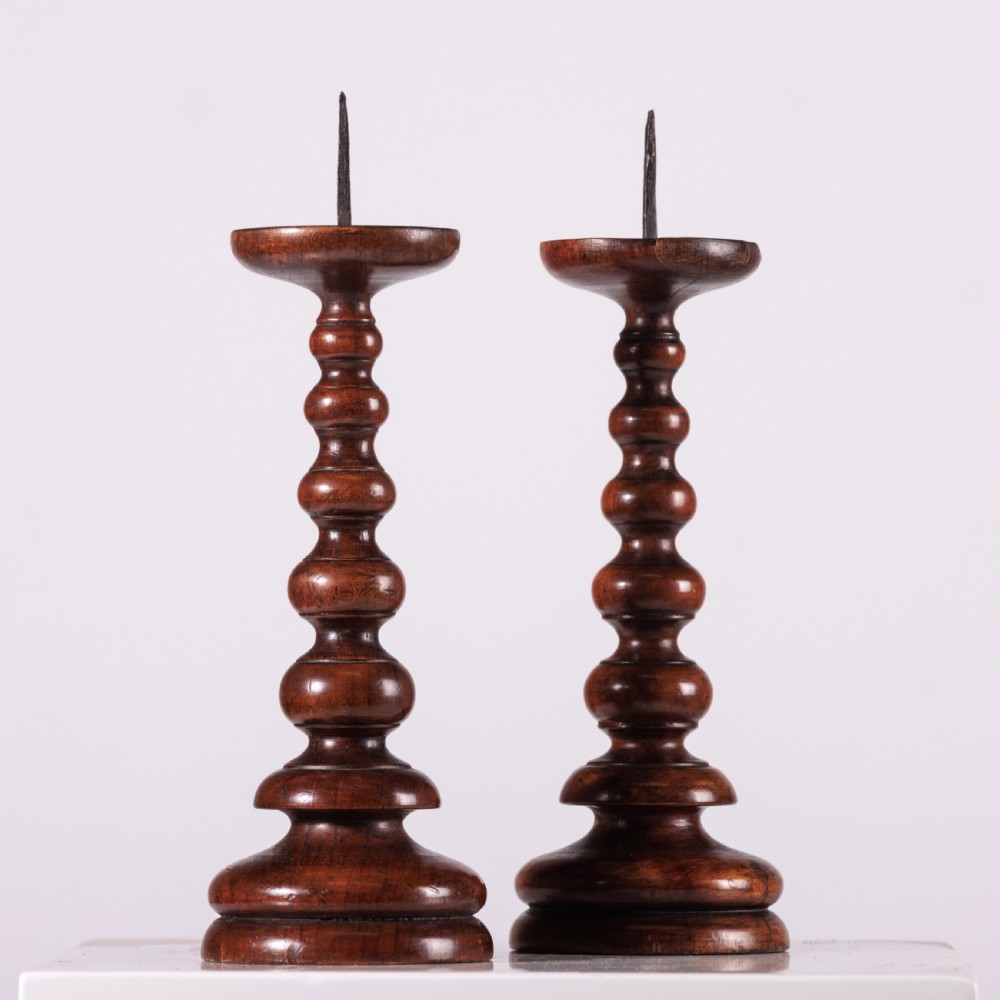 A pair of 18th-century turned dark wood pricket candlesticks featuring iron spikes and stepped circular bases. View II