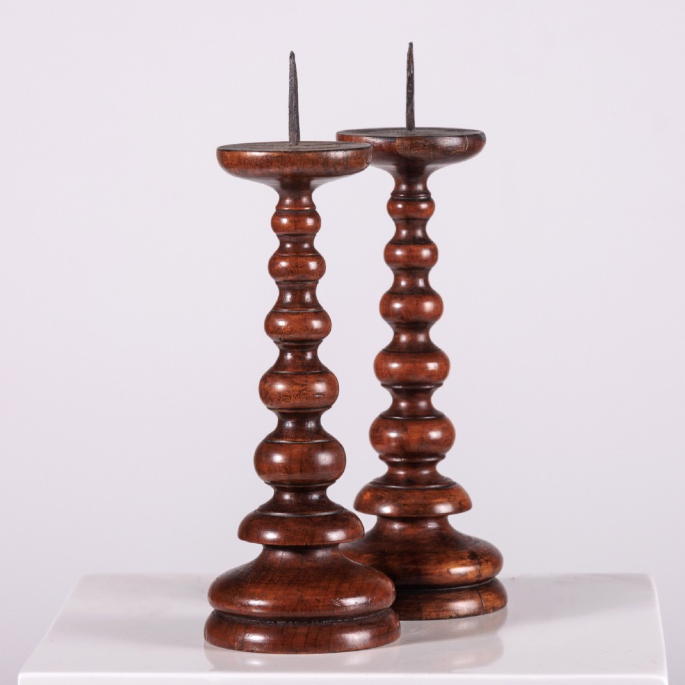 A pair of 18th-century turned dark wood pricket candlesticks featuring iron spikes and stepped circular bases. View IV