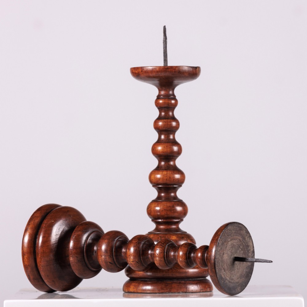 A pair of 18th-century turned dark wood pricket candlesticks featuring iron spikes and stepped circular bases. View VI