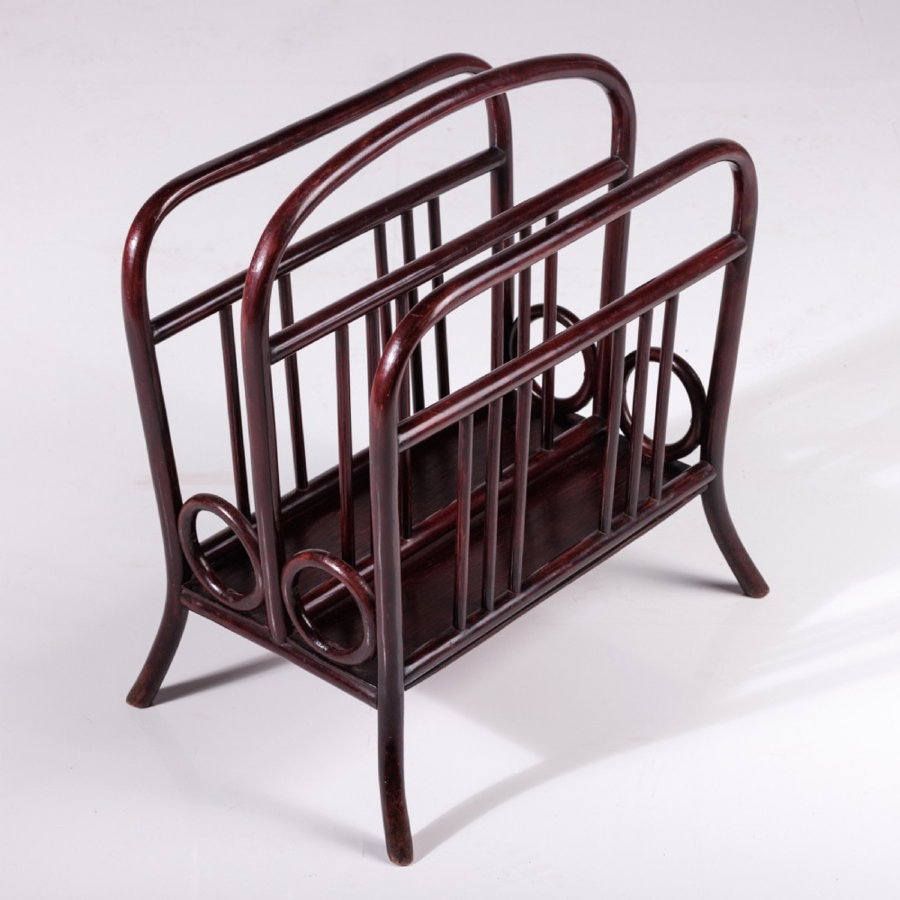 A dark reddish-brown bentwood magazine rack featuring a central arched carrying handle, vertical spindles, and circular bentwood side accents. View II
