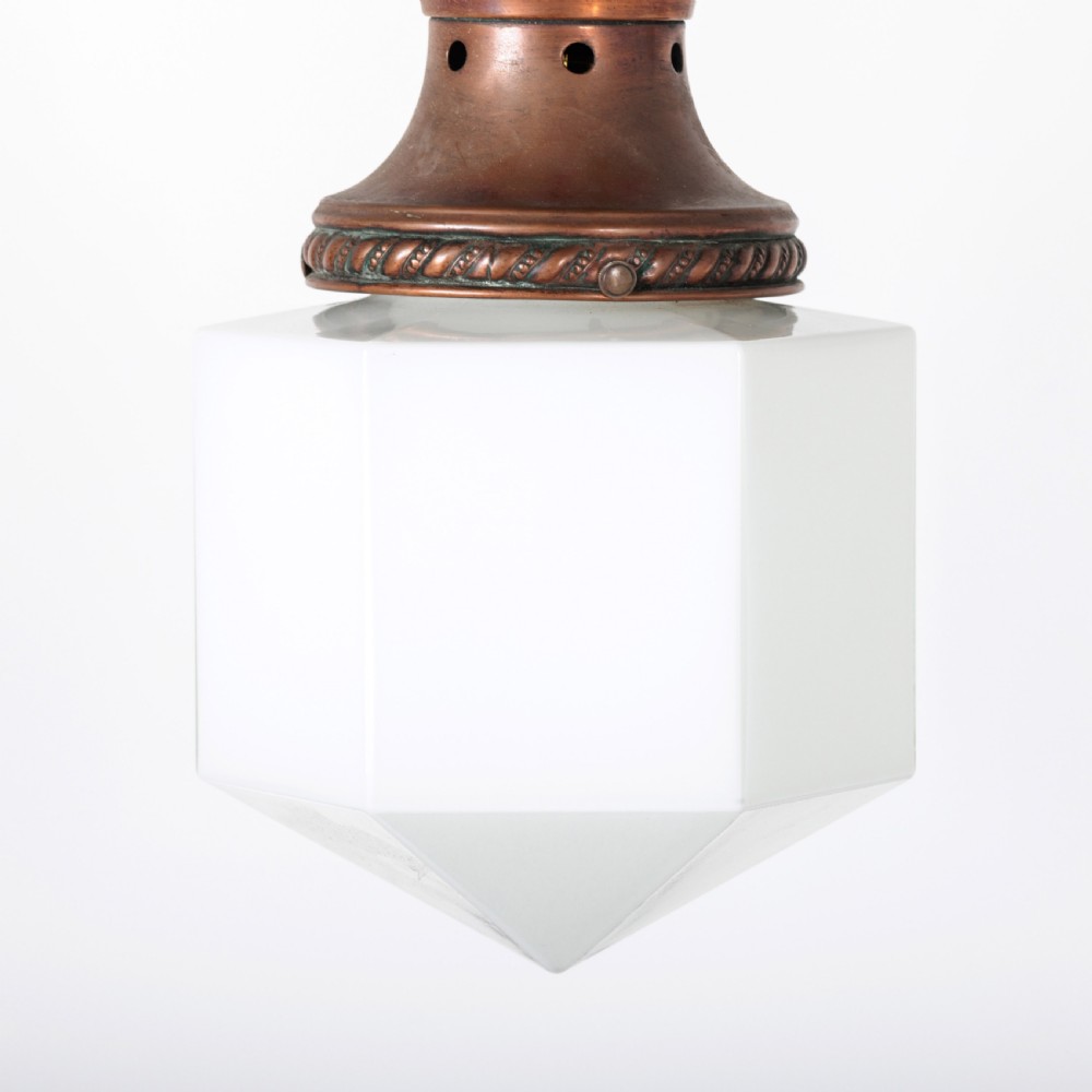 A pair of 1930s Art Deco pendant lights featuring faceted white opal glass hexagonal shades and flared copper top galleries with hanging loop attachments. View VII