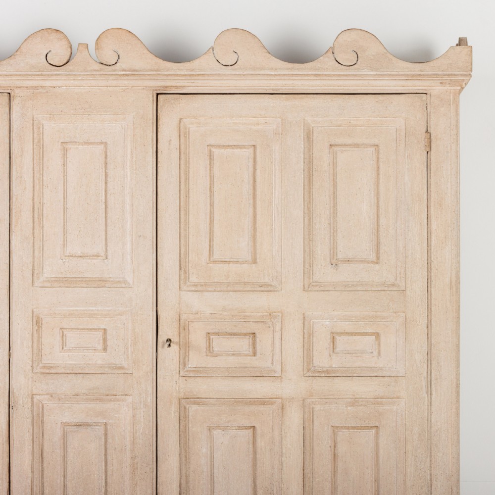 A large 19th-century pale timber dresser featuring a scalloped cornice, panelled upper cupboard doors, and multiple drawers with brass drop handles above a scalloped base. View III
