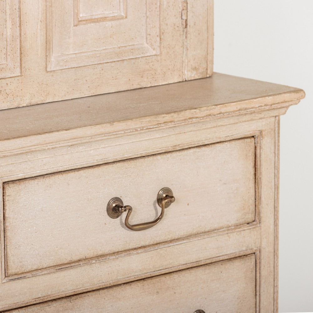 A large 19th-century pale timber dresser featuring a scalloped cornice, panelled upper cupboard doors, and multiple drawers with brass drop handles above a scalloped base. View IV
