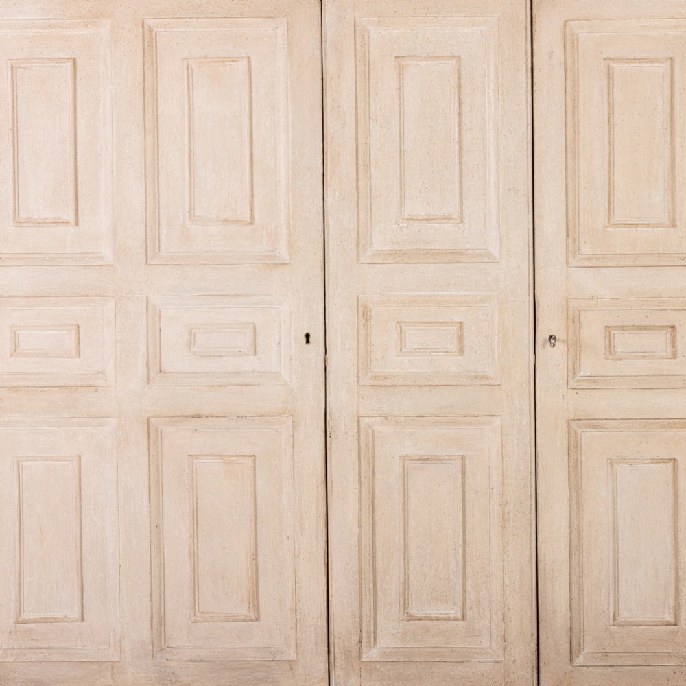 A large 19th-century pale timber dresser featuring a scalloped cornice, panelled upper cupboard doors, and multiple drawers with brass drop handles above a scalloped base. View V