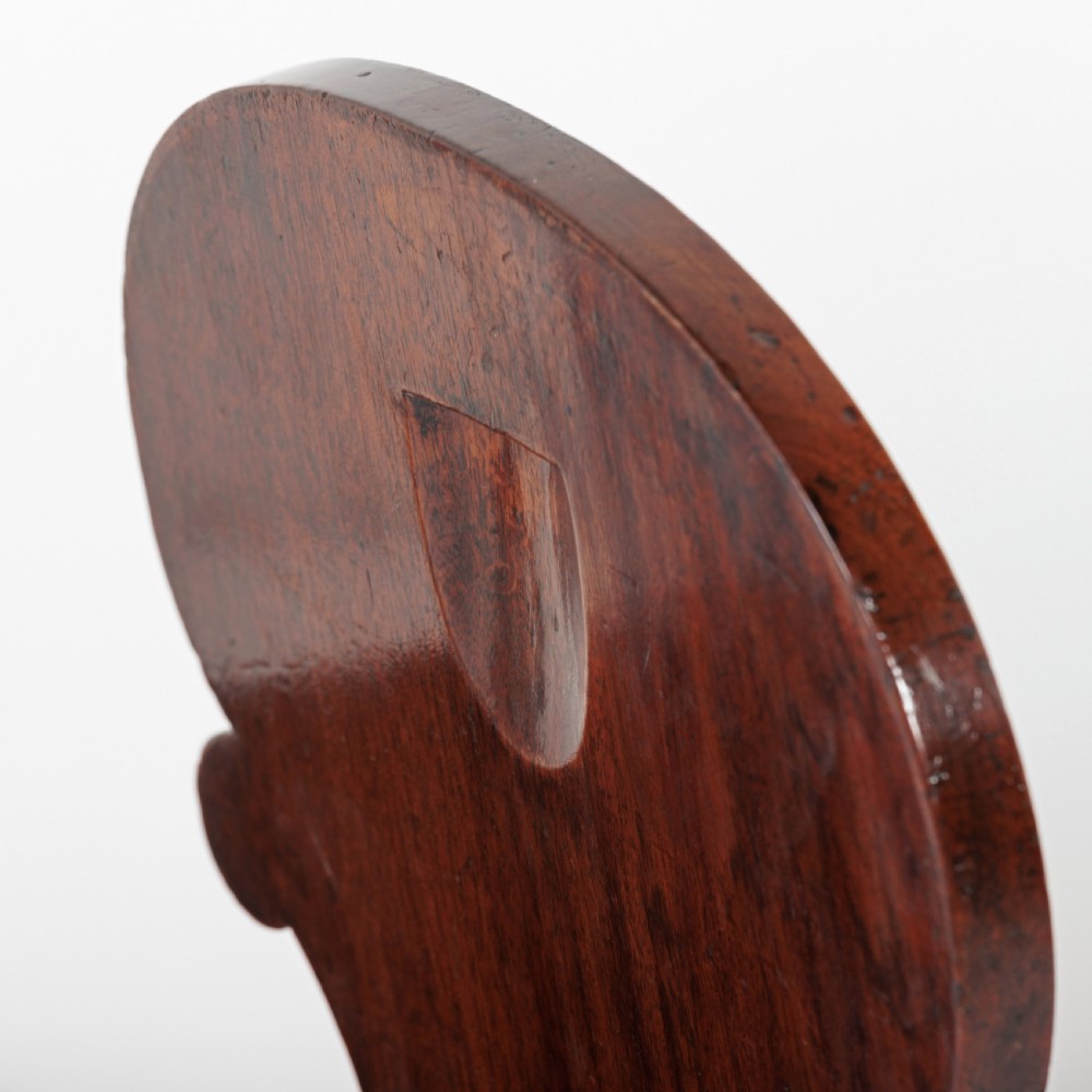 A pair of 19th-century dark mahogany hall chairs featuring scroll-carved backrests with central circular medallions and curved front legs. View VI