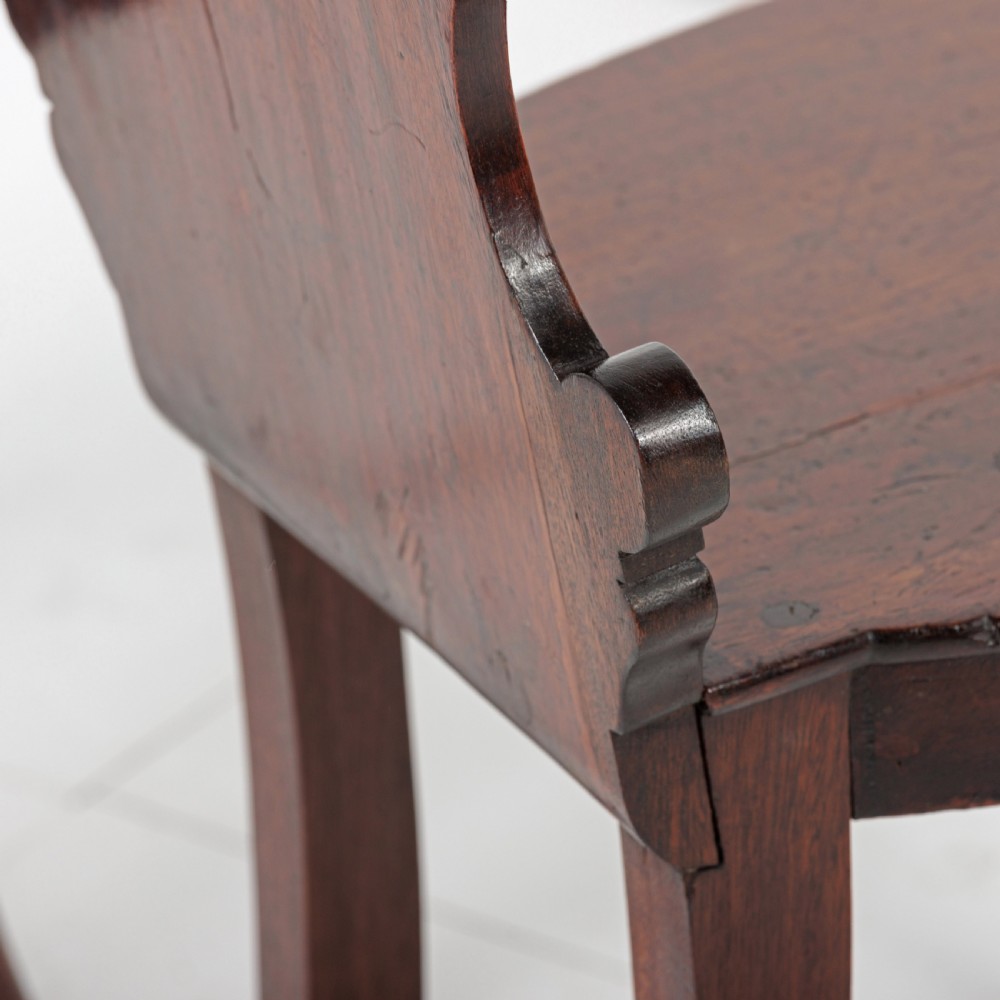 A pair of 19th-century dark mahogany hall chairs featuring scroll-carved backrests with central circular medallions and curved front legs. View VIII