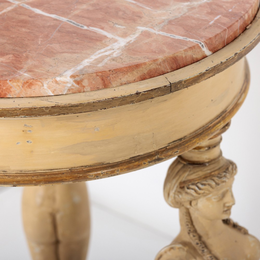 A 19th-century French Empire style circular gueridon table with a pink marble top supported by three carved cream-painted caryatid legs terminating in paw feet. View III