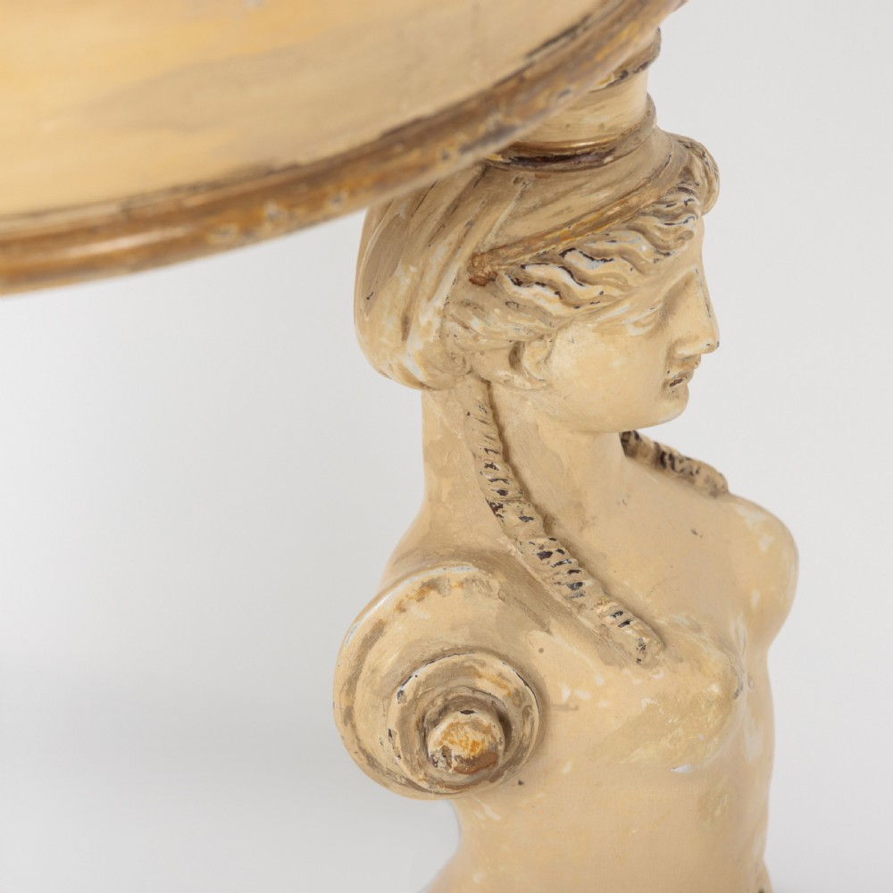 A 19th-century French Empire style circular gueridon table with a pink marble top supported by three carved cream-painted caryatid legs terminating in paw feet. View VII