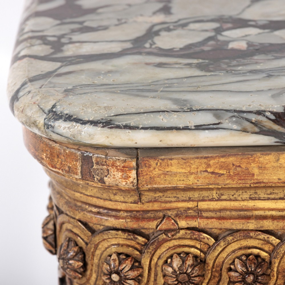 A 19th-century French giltwood console table featuring a grey and white marble top, carved guilloche apron, and spirally fluted tapered legs. View IV