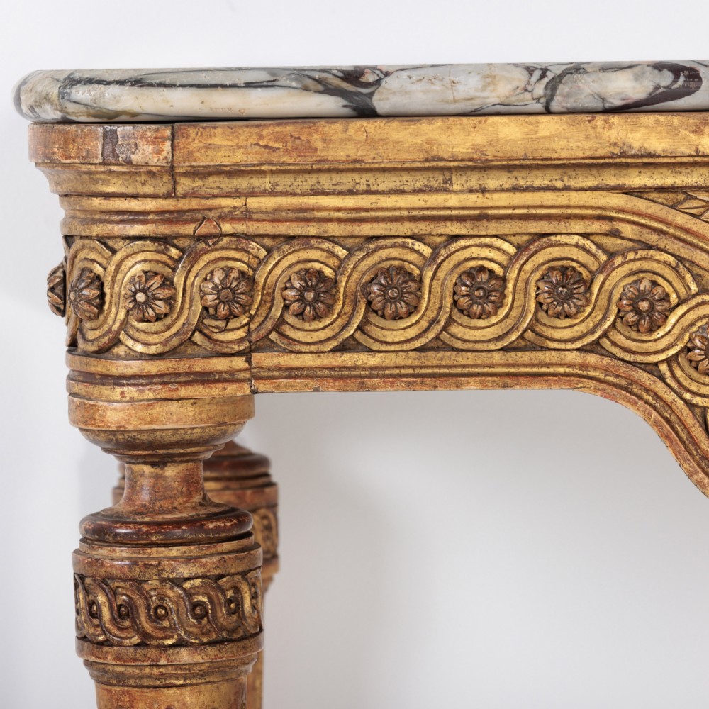 A 19th-century French giltwood console table featuring a grey and white marble top, carved guilloche apron, and spirally fluted tapered legs. View V