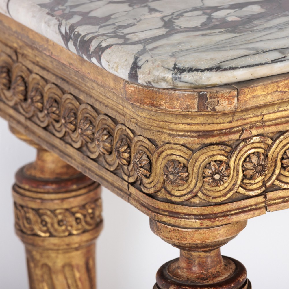 A 19th-century French giltwood console table featuring a grey and white marble top, carved guilloche apron, and spirally fluted tapered legs. View XII
