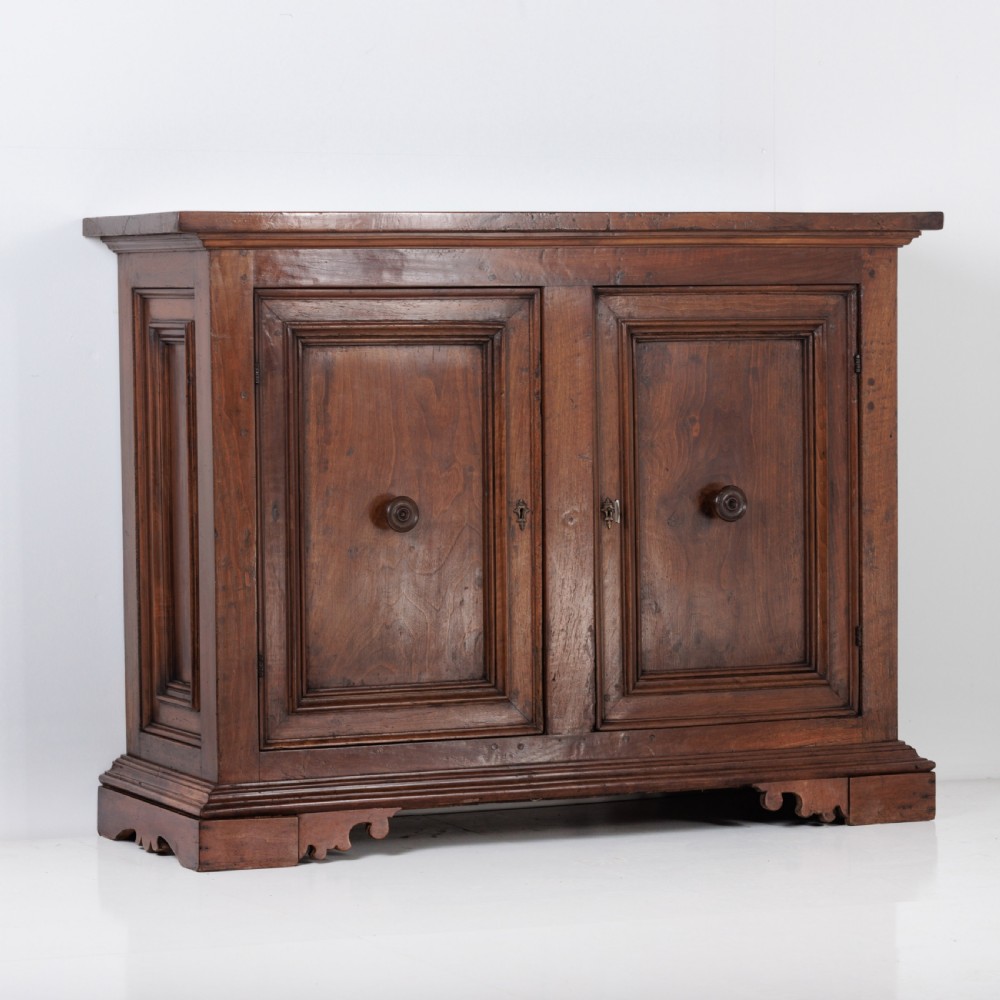 A 19th-century Tuscan walnut cupboard featuring two double-moulded panel doors with turned knobs and a shaped plinth base. View II