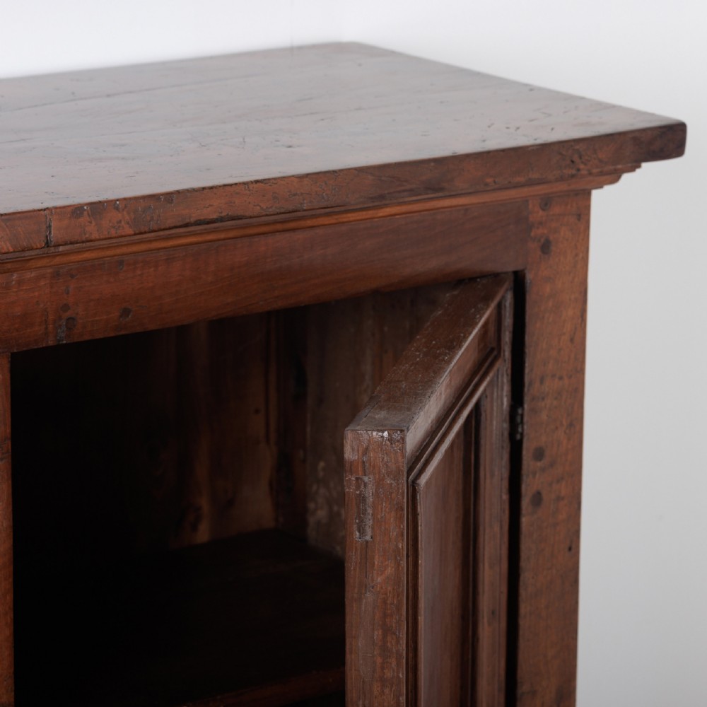 A 19th-century Tuscan walnut cupboard featuring two double-moulded panel doors with turned knobs and a shaped plinth base. View VII