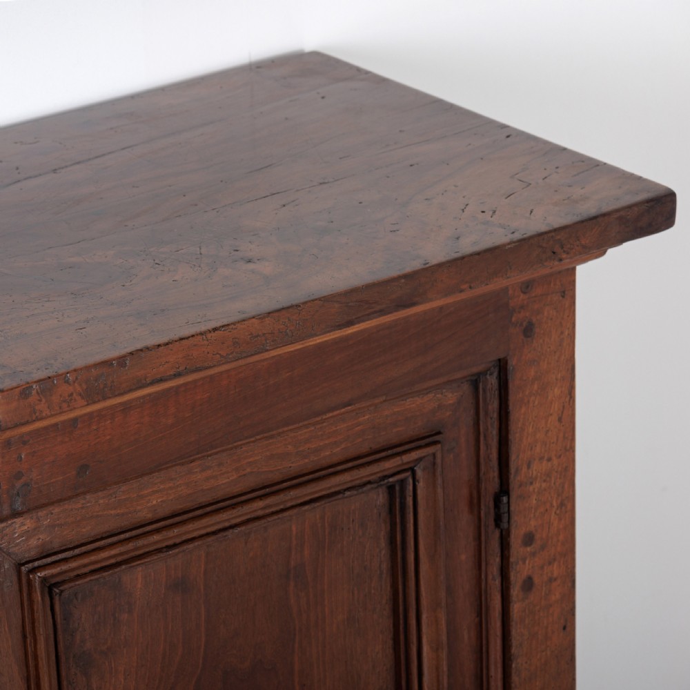 A 19th-century Tuscan walnut cupboard featuring two double-moulded panel doors with turned knobs and a shaped plinth base. View IX