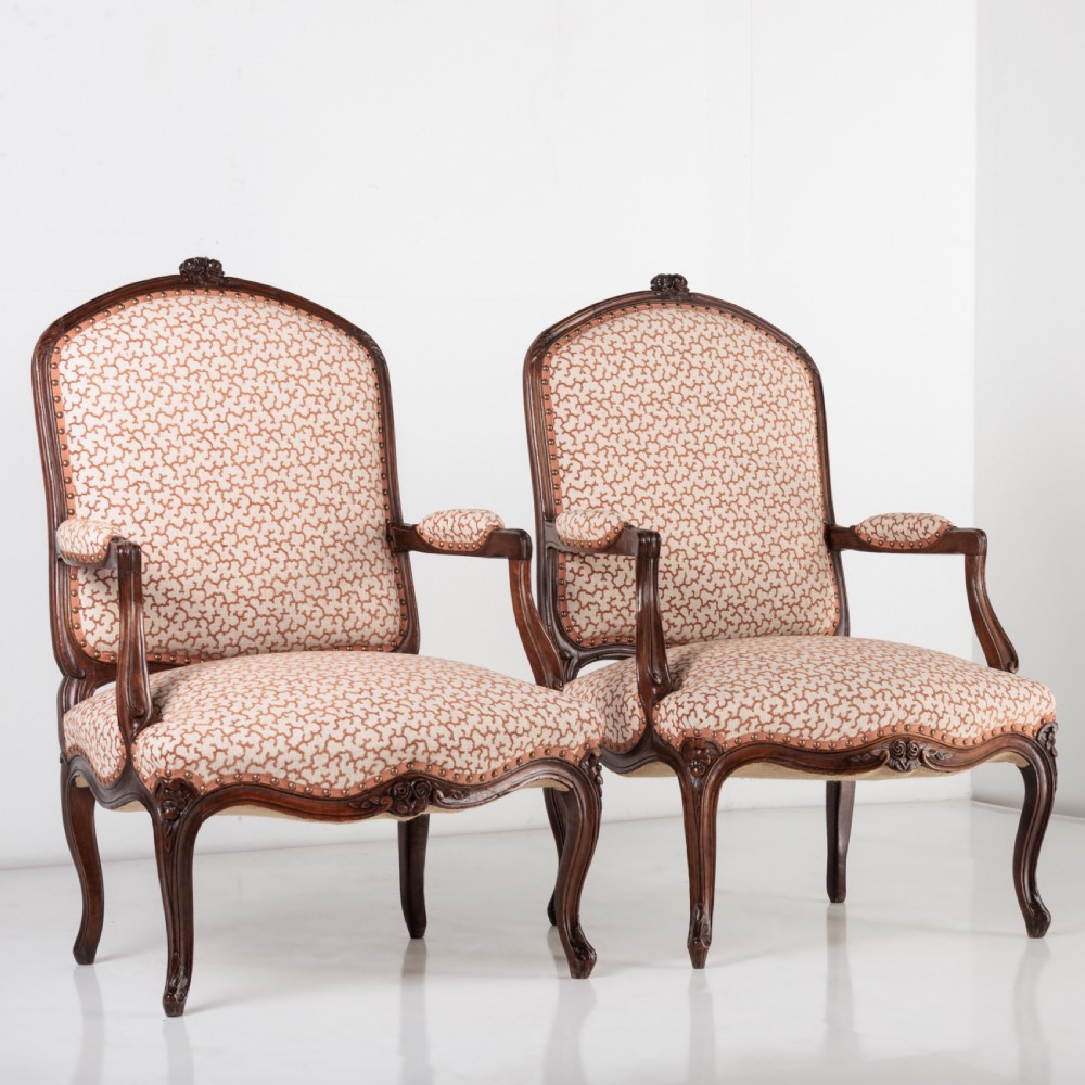 A pair of 19th-century French Louis XV style fauteuil armchairs with carved walnut frames, cabriole legs, brass stud trim, and patterned cream and brown upholstery. View II