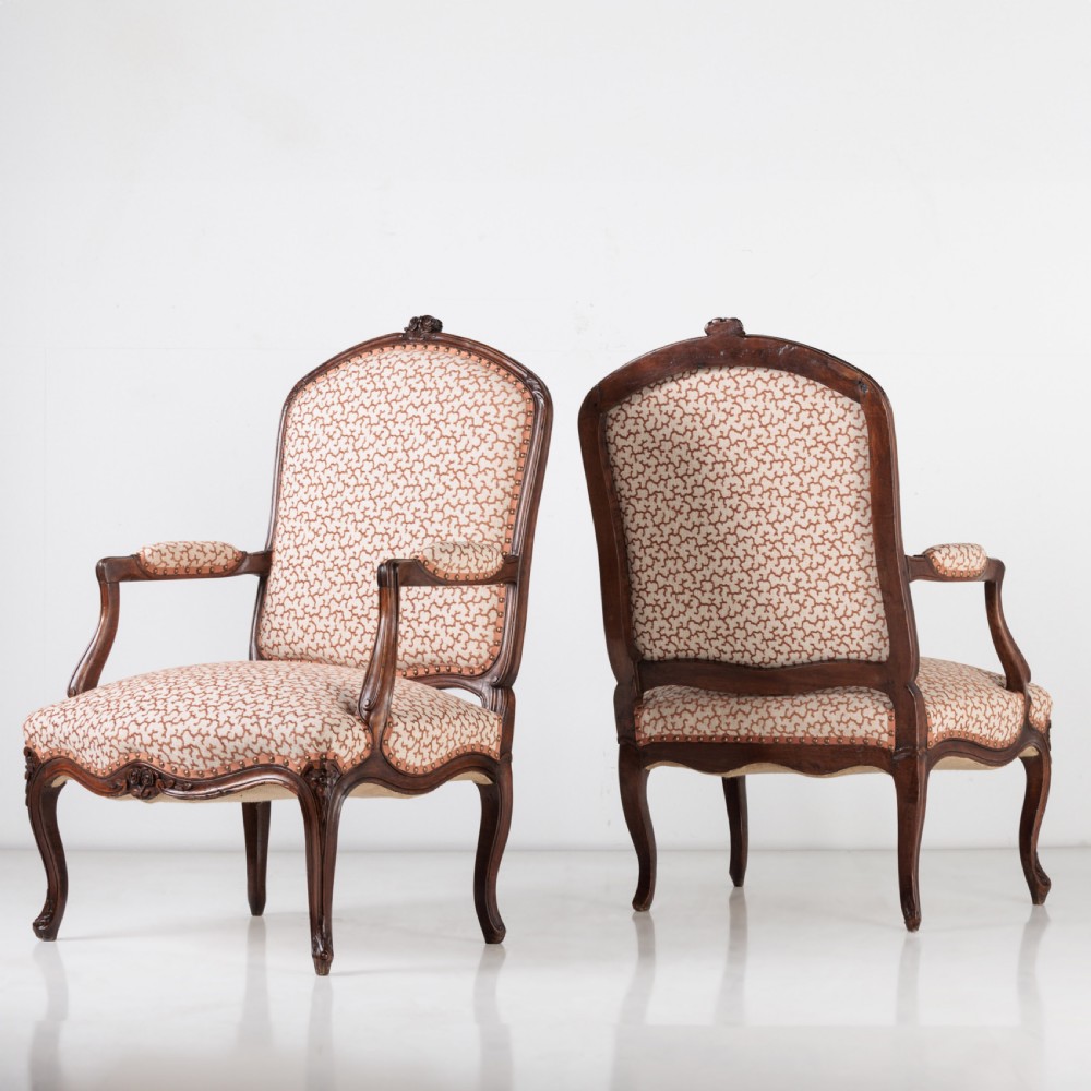A pair of 19th-century French Louis XV style fauteuil armchairs with carved walnut frames, cabriole legs, brass stud trim, and patterned cream and brown upholstery. View VI