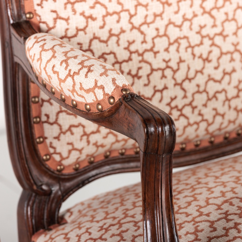 A pair of 19th-century French Louis XV style fauteuil armchairs with carved walnut frames, cabriole legs, brass stud trim, and patterned cream and brown upholstery. View VII