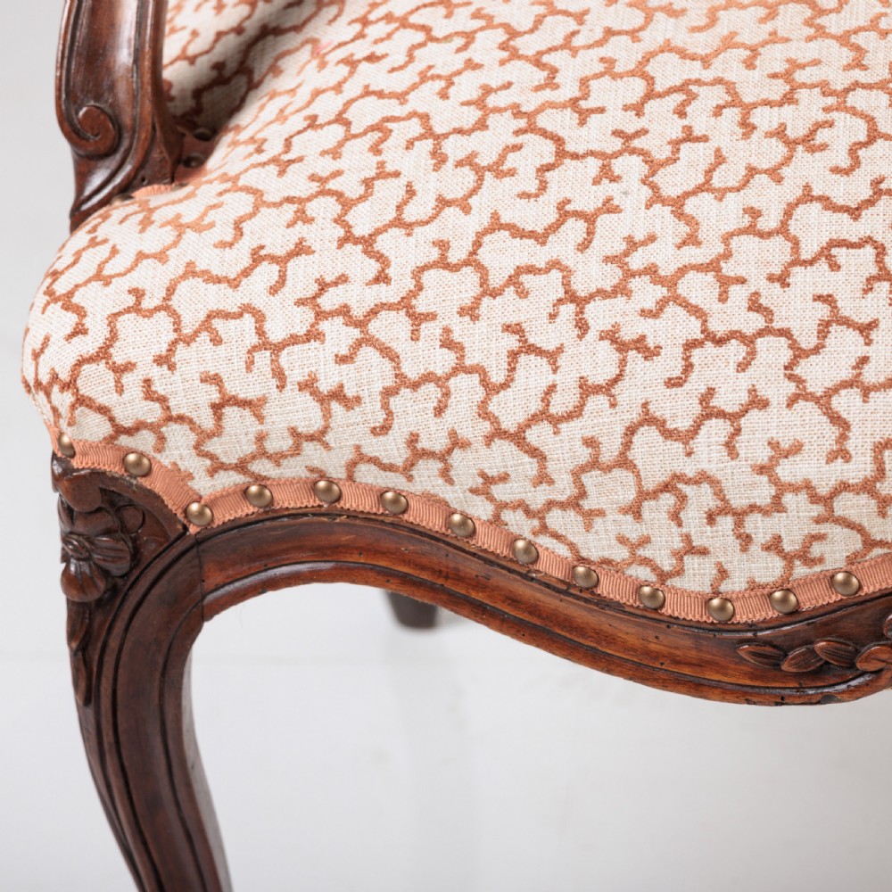 A pair of 19th-century French Louis XV style fauteuil armchairs with carved walnut frames, cabriole legs, brass stud trim, and patterned cream and brown upholstery. View VIII