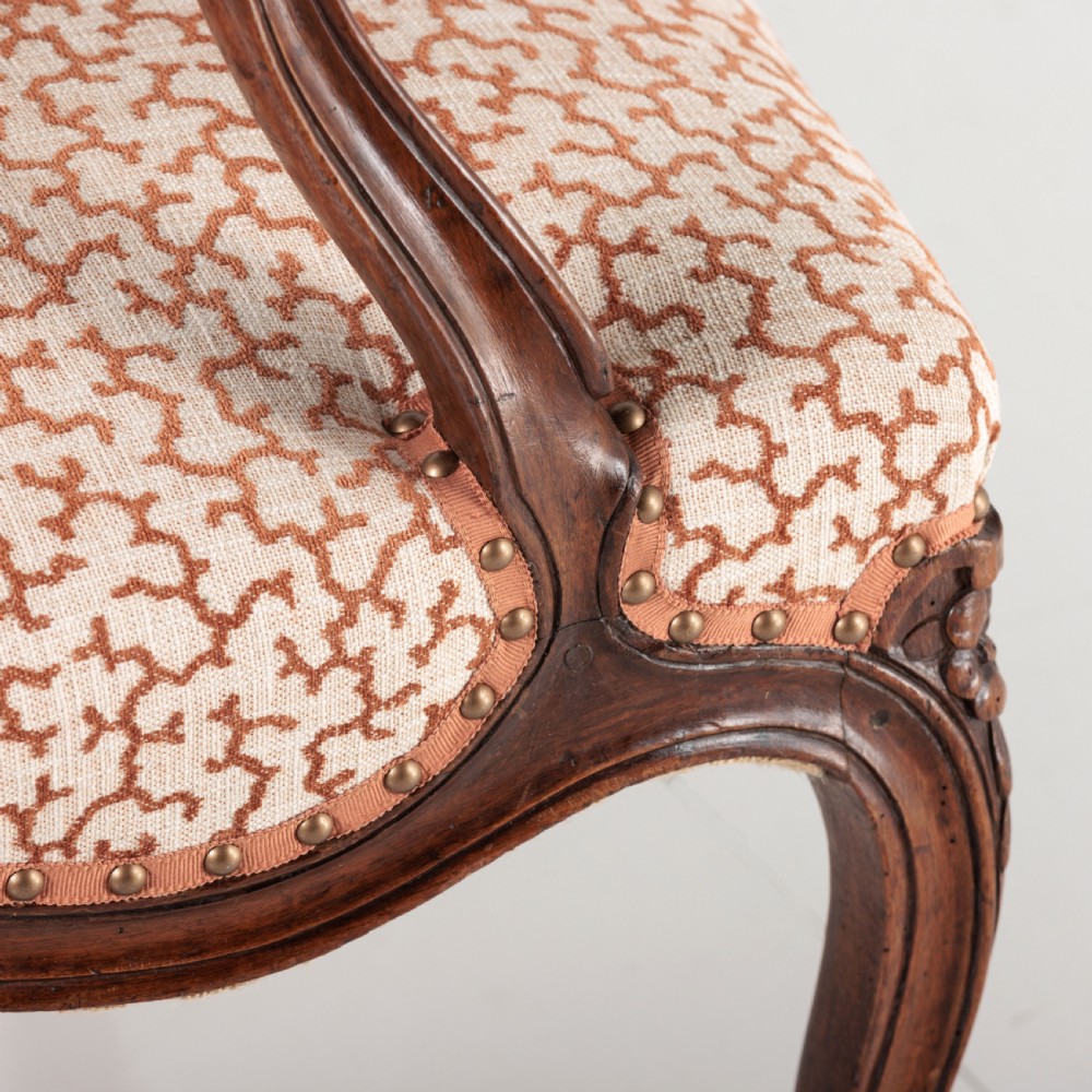 A pair of 19th-century French Louis XV style fauteuil armchairs with carved walnut frames, cabriole legs, brass stud trim, and patterned cream and brown upholstery. View XIII