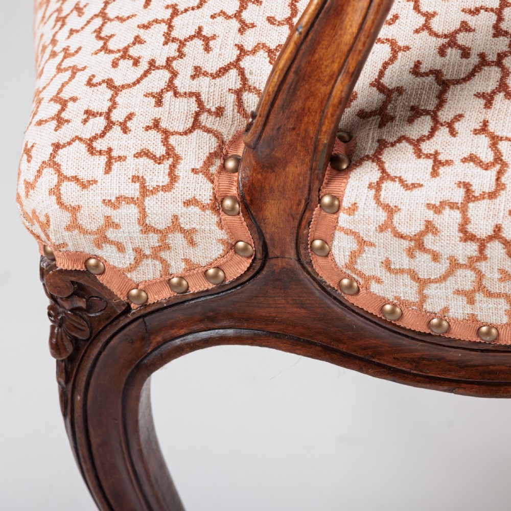 A pair of 19th-century French Louis XV style fauteuil armchairs with carved walnut frames, cabriole legs, brass stud trim, and patterned cream and brown upholstery. View XIV