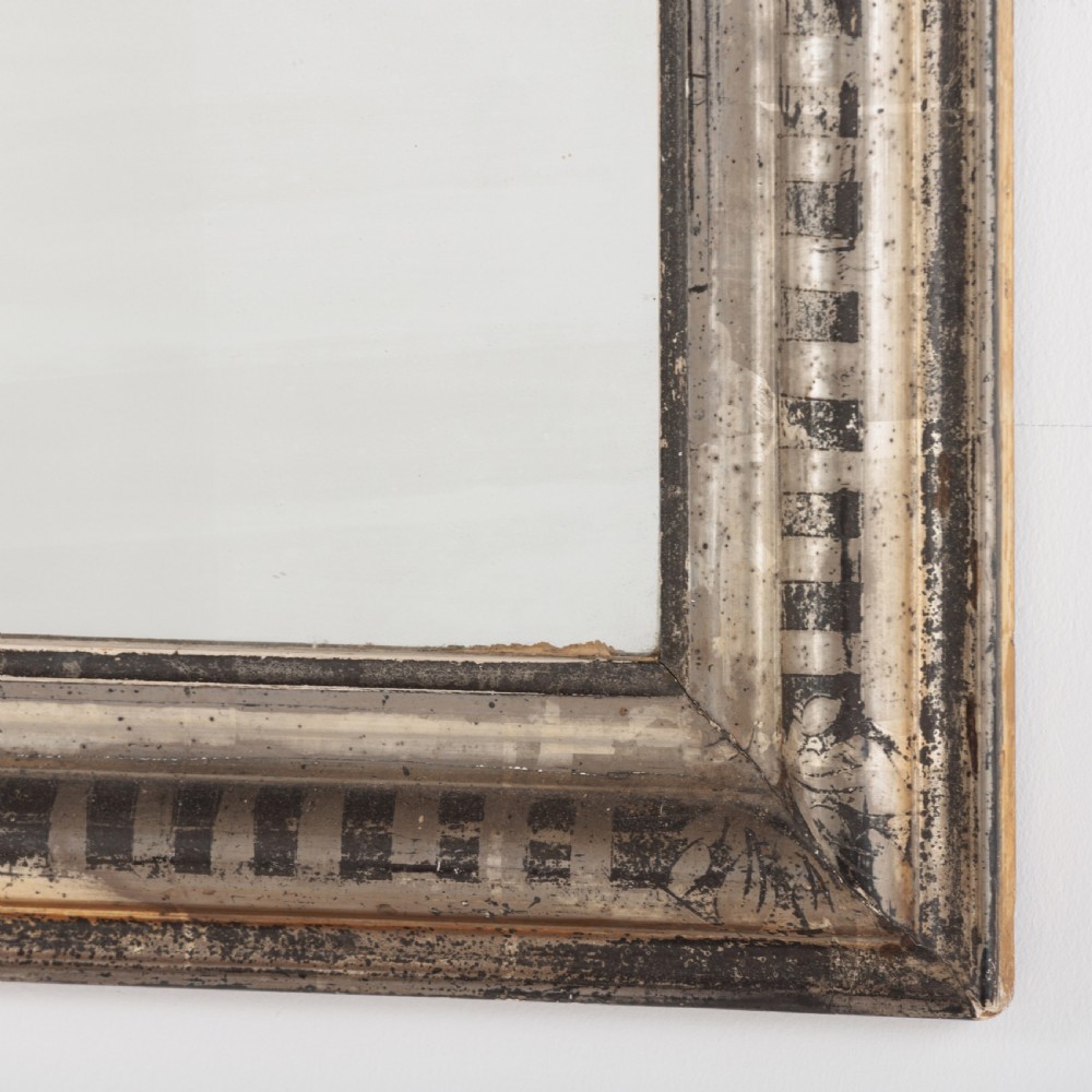 A 19th-century French Louis Philippe wall mirror featuring a silver leaf finish with a striped incised motif, rounded upper corners, and a flat base. View V
