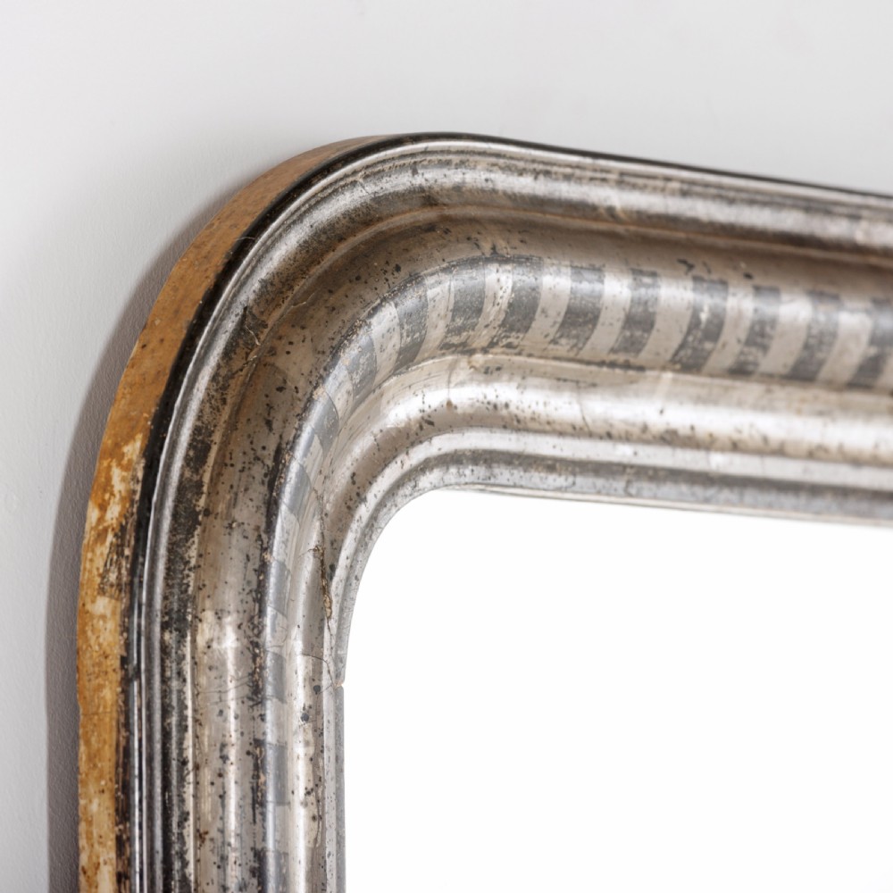 A 19th-century French Louis Philippe wall mirror featuring a silver leaf finish with a striped incised motif, rounded upper corners, and a flat base. View VI