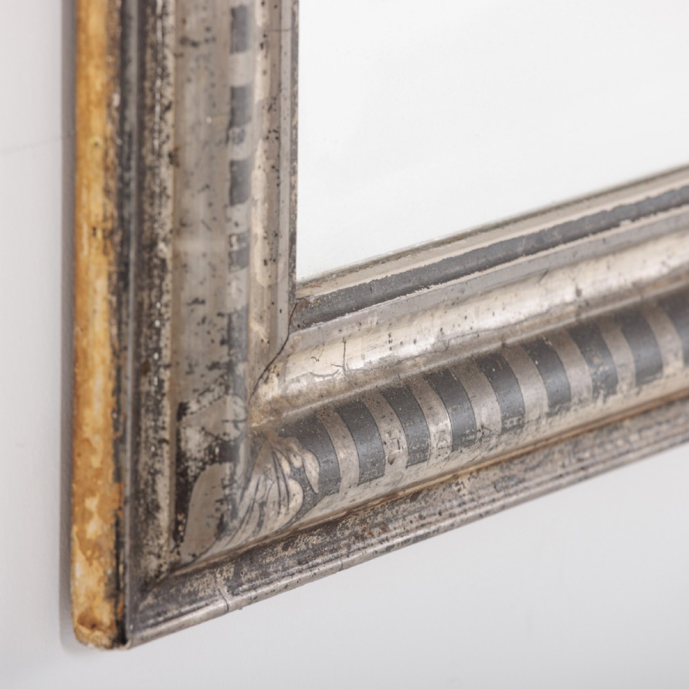 A 19th-century French Louis Philippe wall mirror featuring a silver leaf finish with a striped incised motif, rounded upper corners, and a flat base. View VII