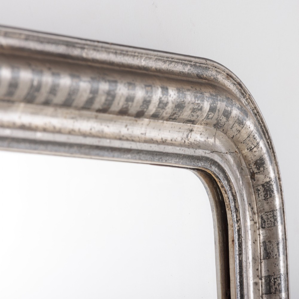 A 19th-century French Louis Philippe wall mirror featuring a silver leaf finish with a striped incised motif, rounded upper corners, and a flat base. View VIII