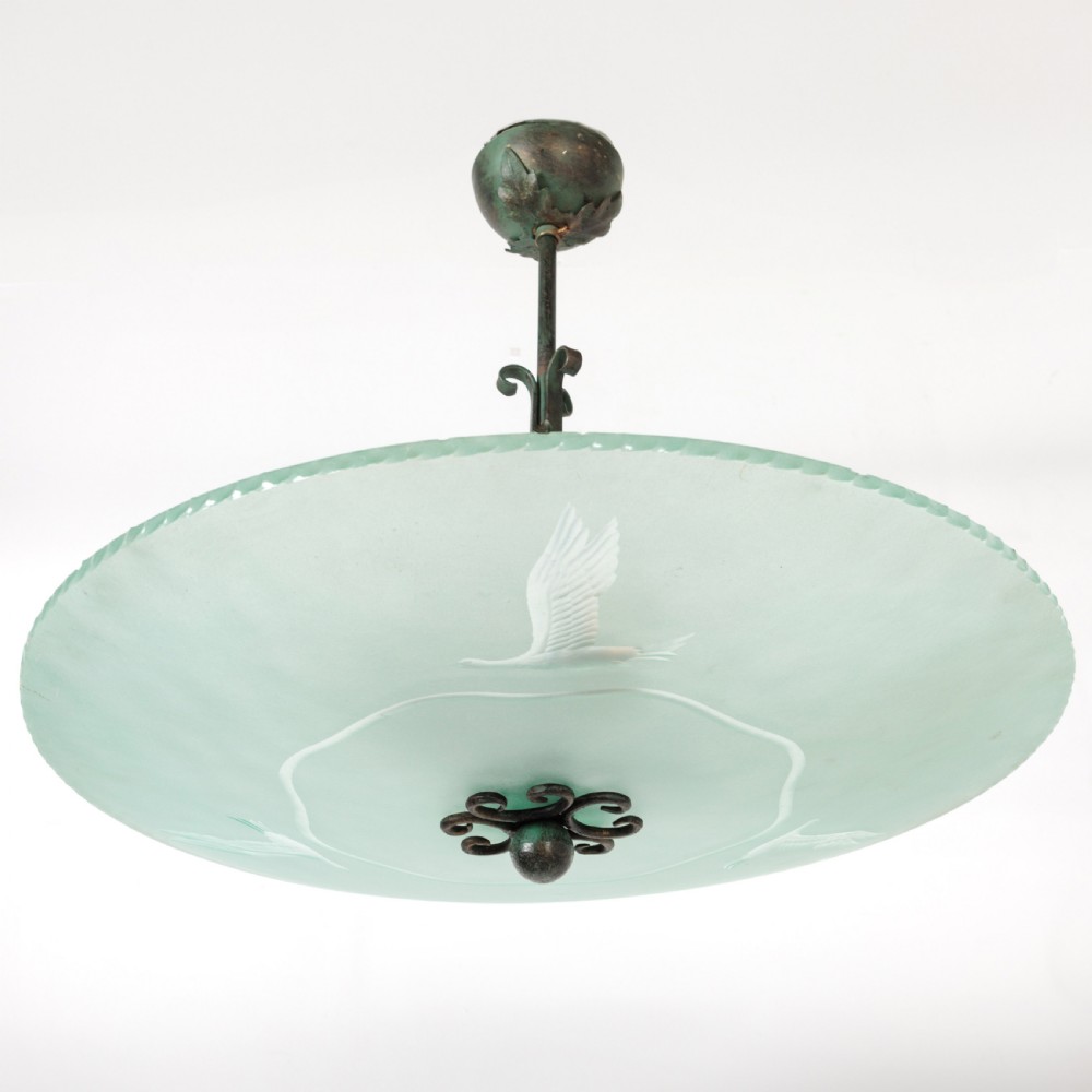 A shallow pale green frosted glass dish ceiling light featuring etched flying crane motifs and patinated metal central fittings.