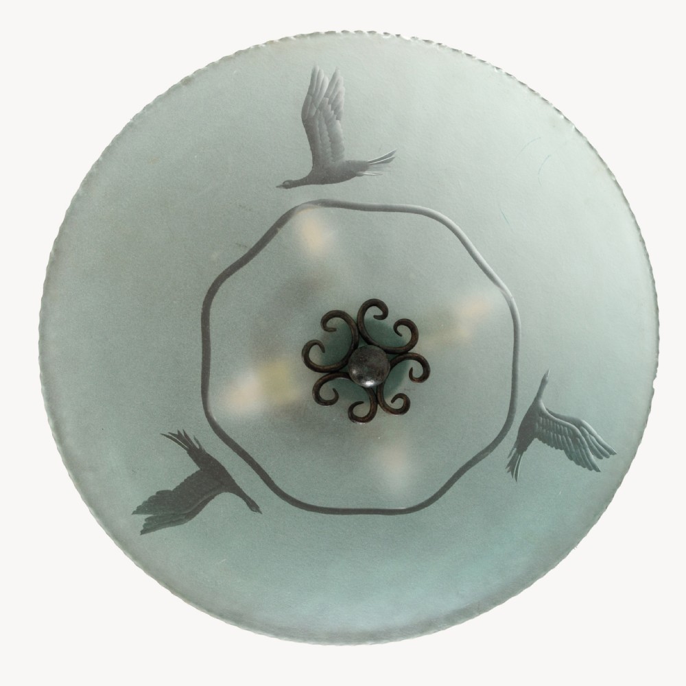 A shallow pale green frosted glass dish ceiling light featuring etched flying crane motifs and patinated metal central fittings. View VI
