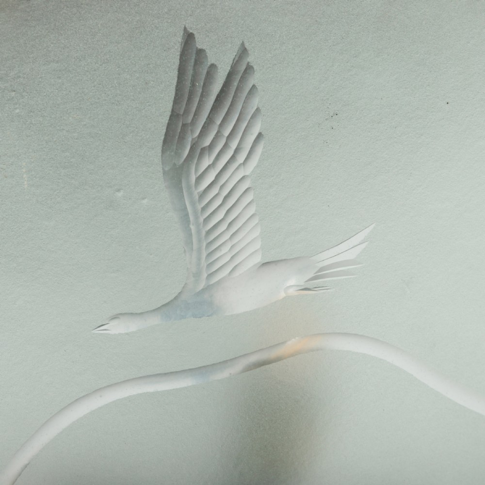 A shallow pale green frosted glass dish ceiling light featuring etched flying crane motifs and patinated metal central fittings. View VII