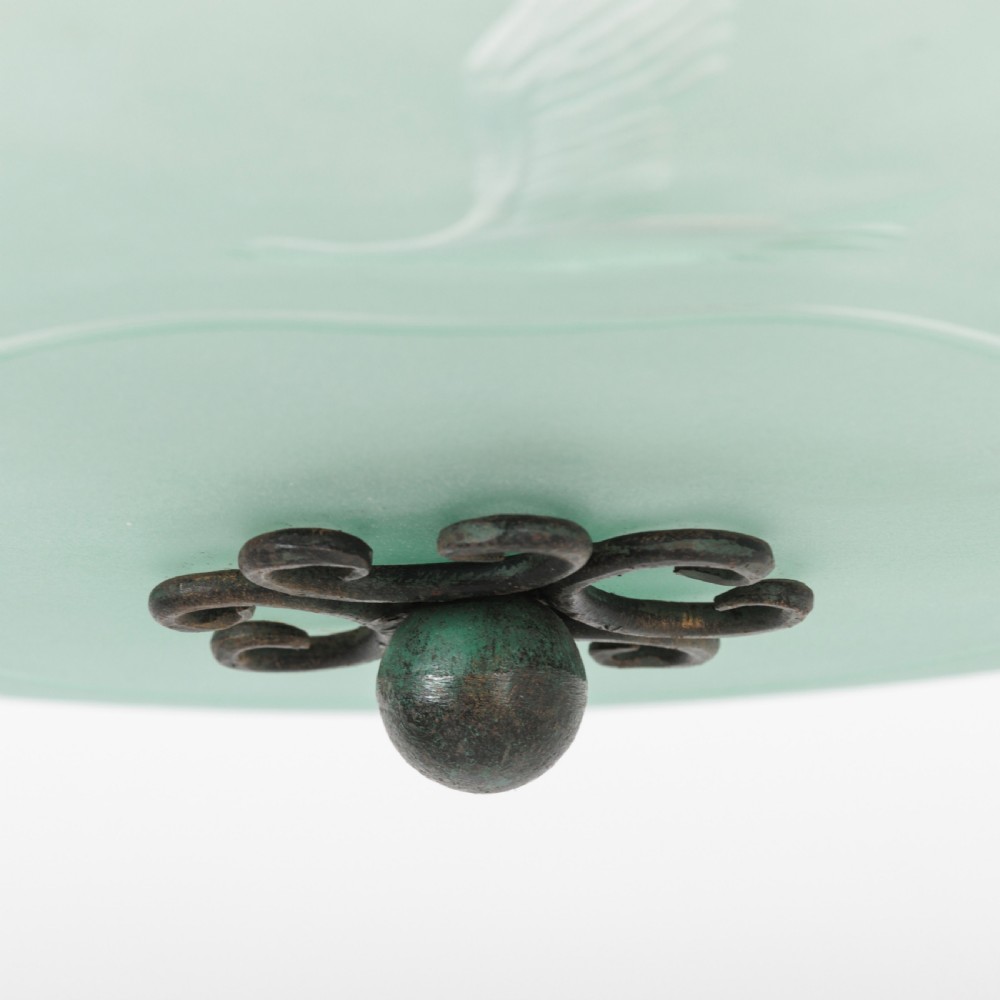 A shallow pale green frosted glass dish ceiling light featuring etched flying crane motifs and patinated metal central fittings. View X