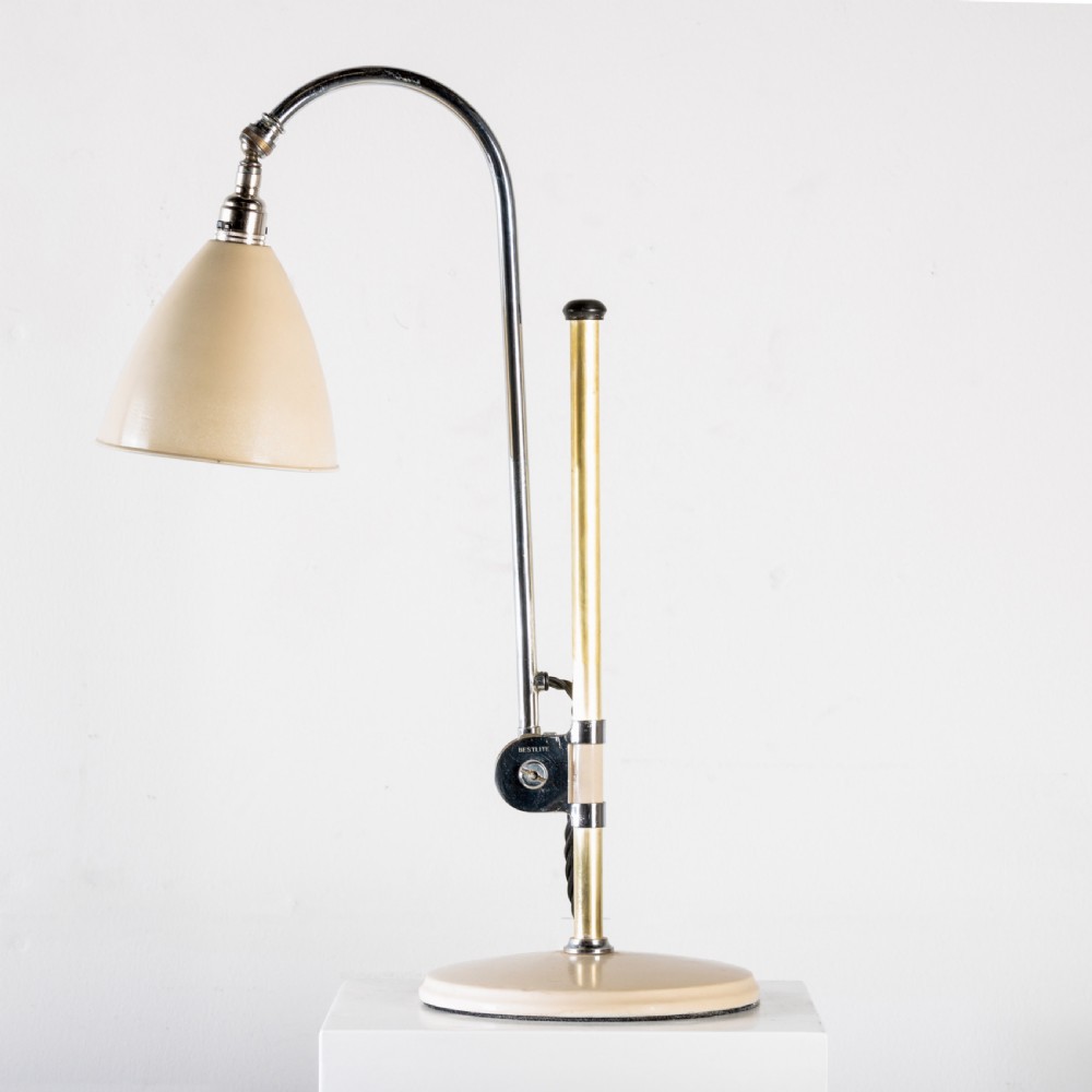 A 1930s Bestlite desk lamp featuring a cream enamelled shade and base, a curved chrome gooseneck arm, and an adjustable brass stem.