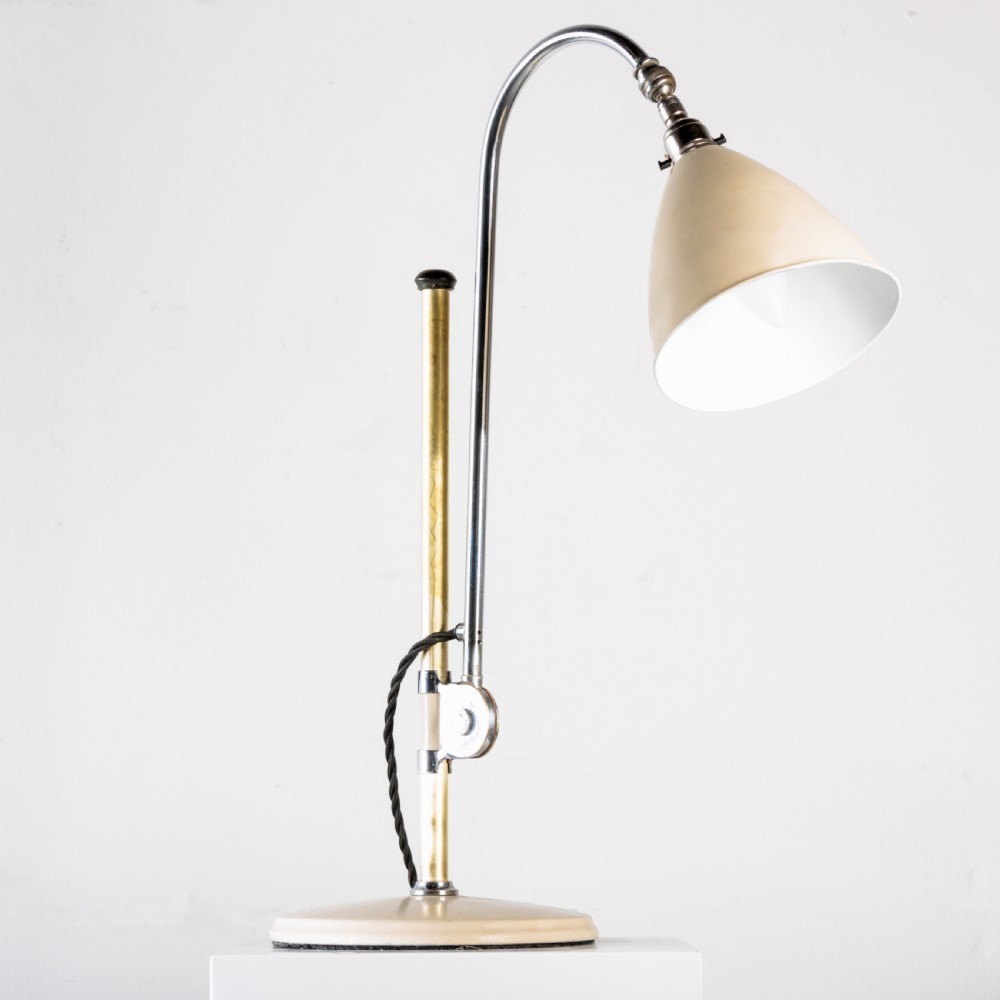 A 1930s Bestlite desk lamp featuring a cream enamelled shade and base, a curved chrome gooseneck arm, and an adjustable brass stem. View V