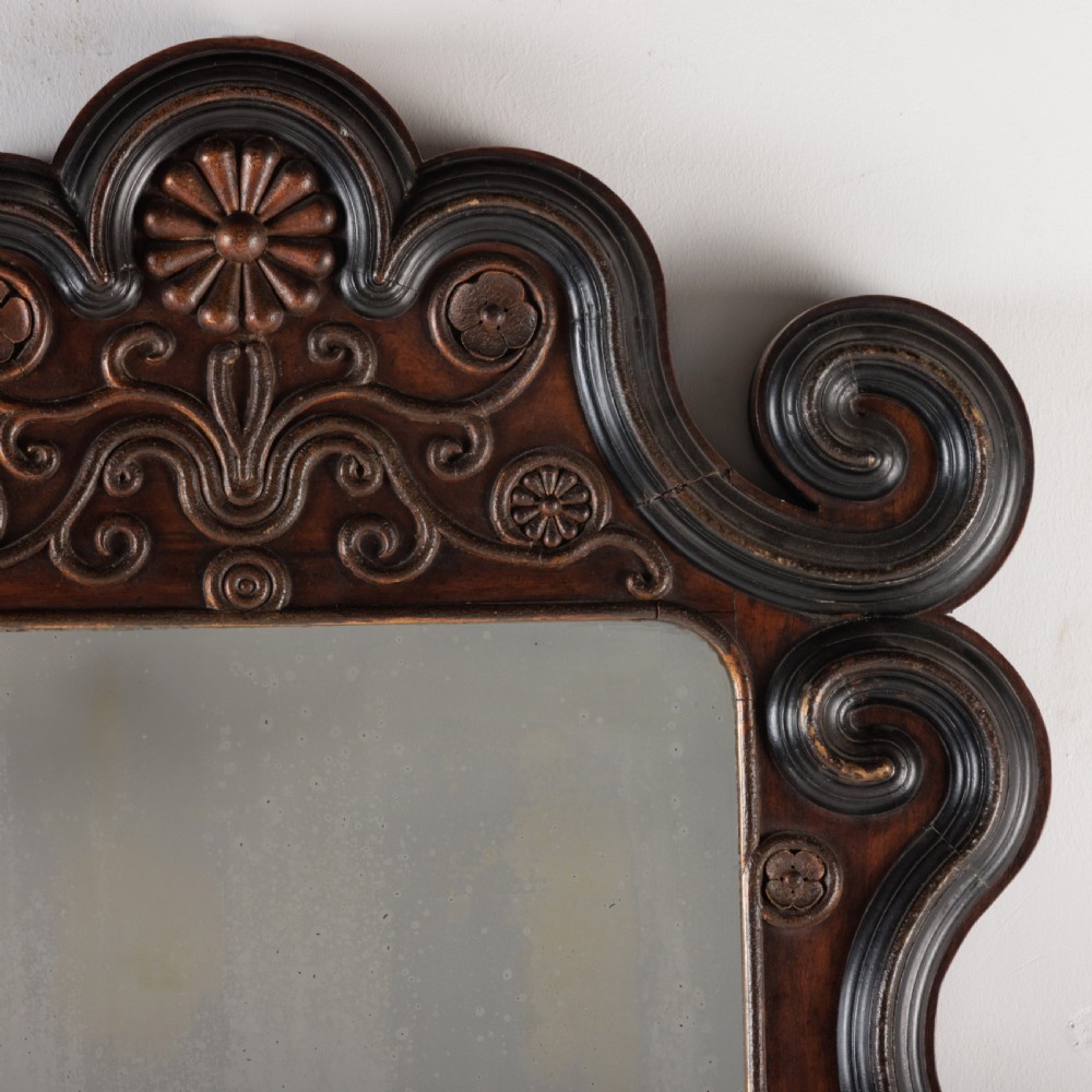 A dark brown carved wood wall mirror featuring elaborate scrollwork, rosette medallions, and a rectangular mirror glass. View II