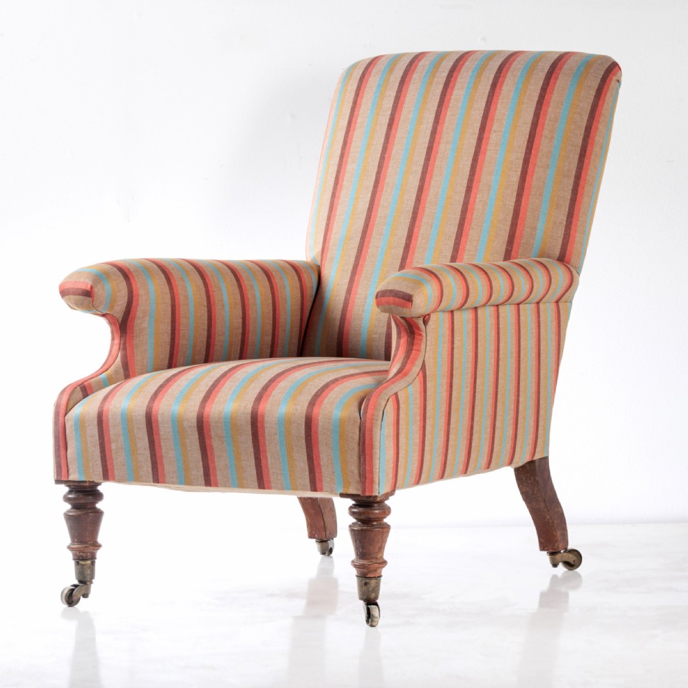 A 19th-century Victorian easy armchair upholstered in vertical stripes of terracotta, blue, beige, and gold with turned timber front legs on brass castors. View IV