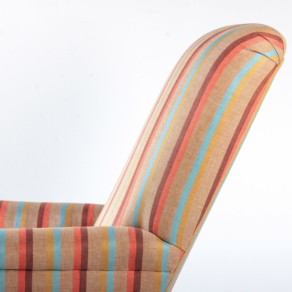 A 19th-century Victorian easy armchair upholstered in vertical stripes of terracotta, blue, beige, and gold with turned timber front legs on brass castors. View XI