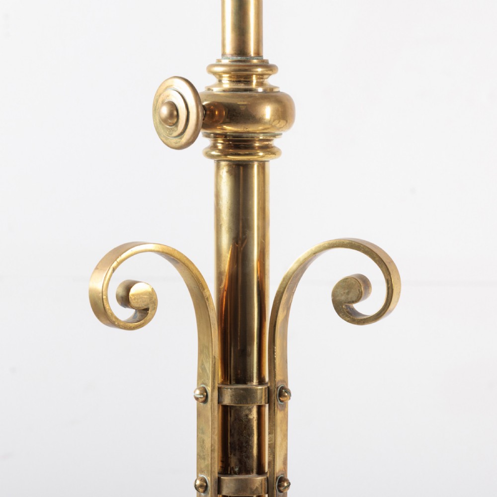 A pair of antique brass standard floor lamps featuring tripod bases, scrolled design details, and green striped pleated fabric shades. View II