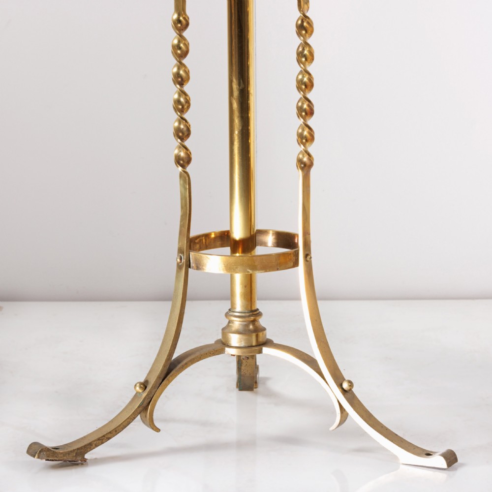A pair of antique brass standard floor lamps featuring tripod bases, scrolled design details, and green striped pleated fabric shades. View V