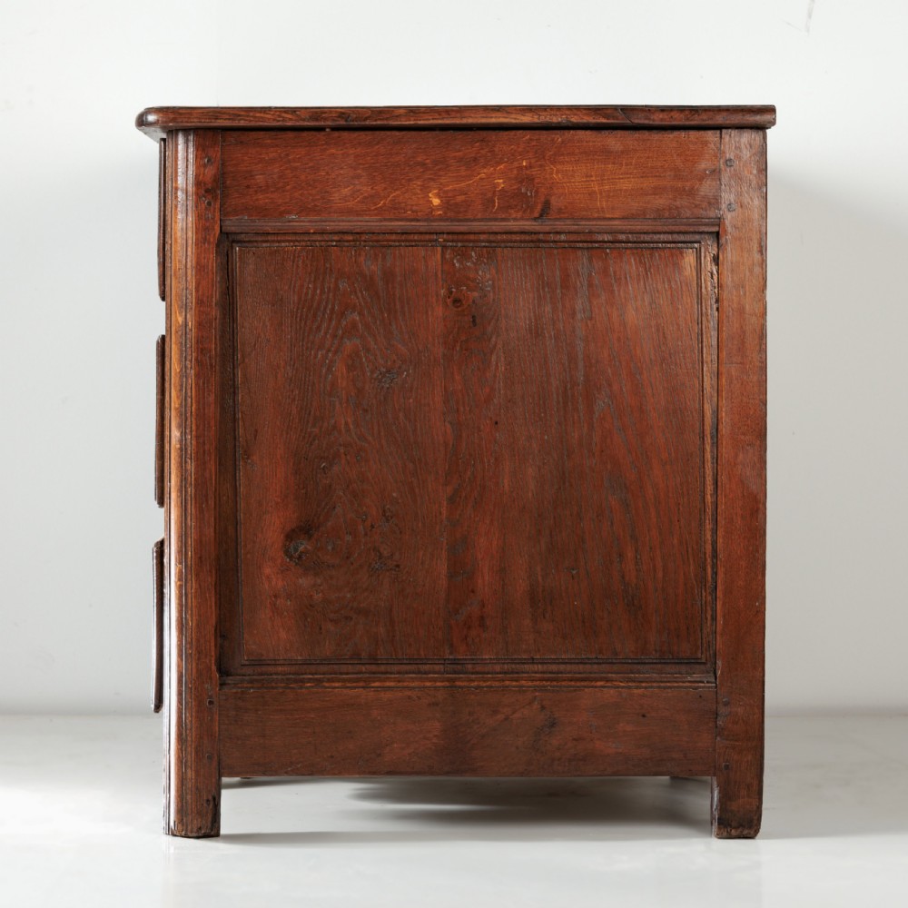 A nineteenth-century provincial oak chest of drawers with three full-width drawers featuring metal drop handles and decorative keyhole escutcheons. View IV