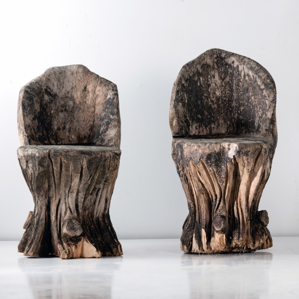 A pair of hand-carved dugout garden seats crafted from solid tree trunks with weathered timber surfaces. View II