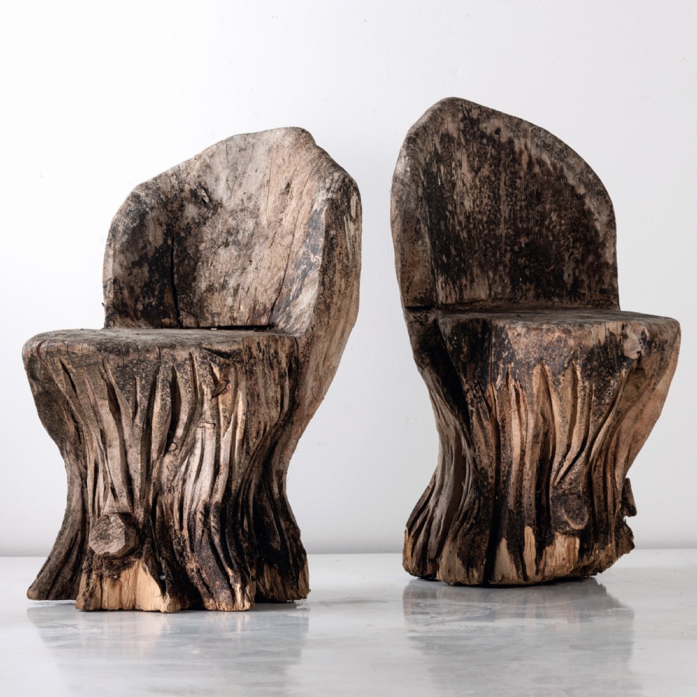 A pair of hand-carved dugout garden seats crafted from solid tree trunks with weathered timber surfaces. View III