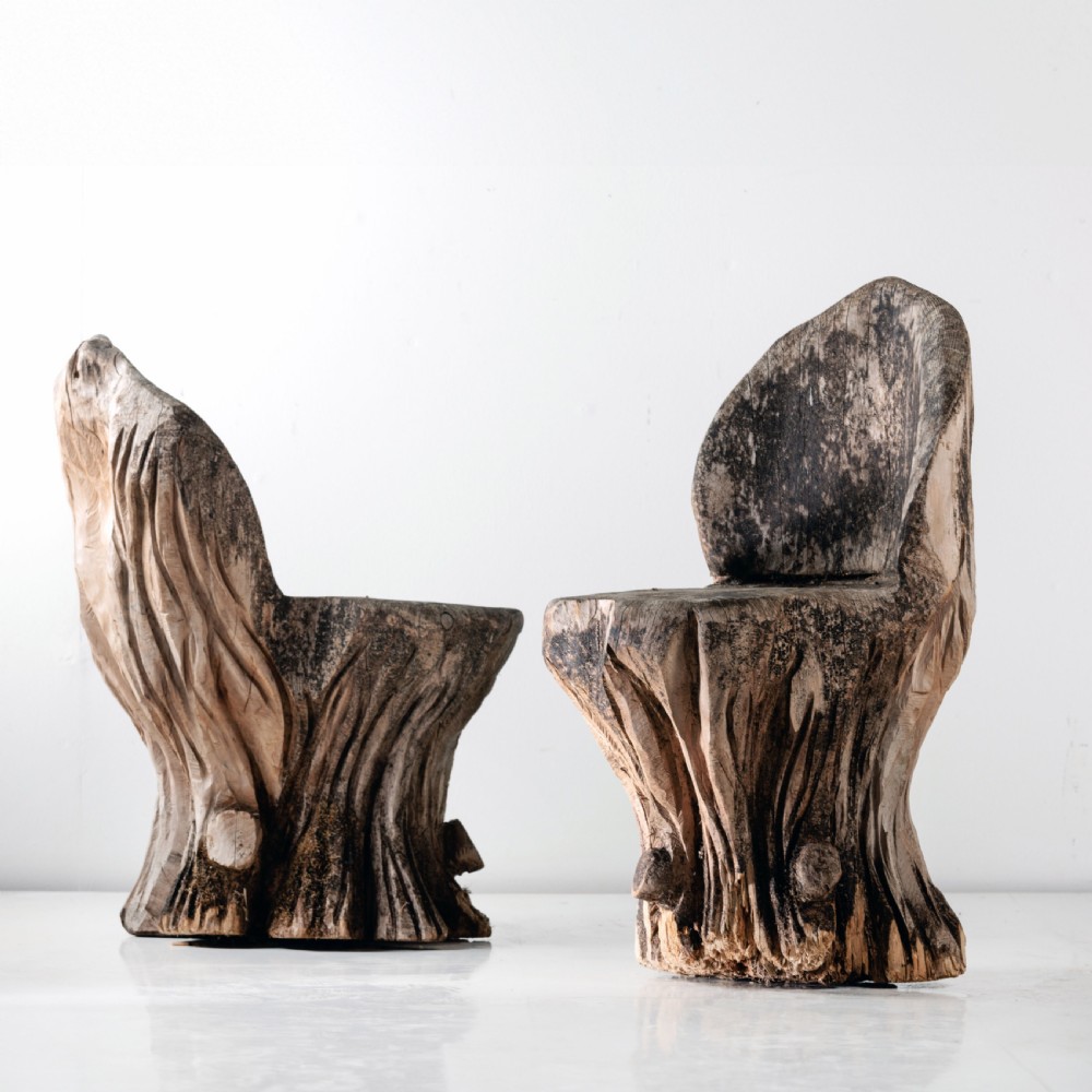 A pair of hand-carved dugout garden seats crafted from solid tree trunks with weathered timber surfaces. View IV